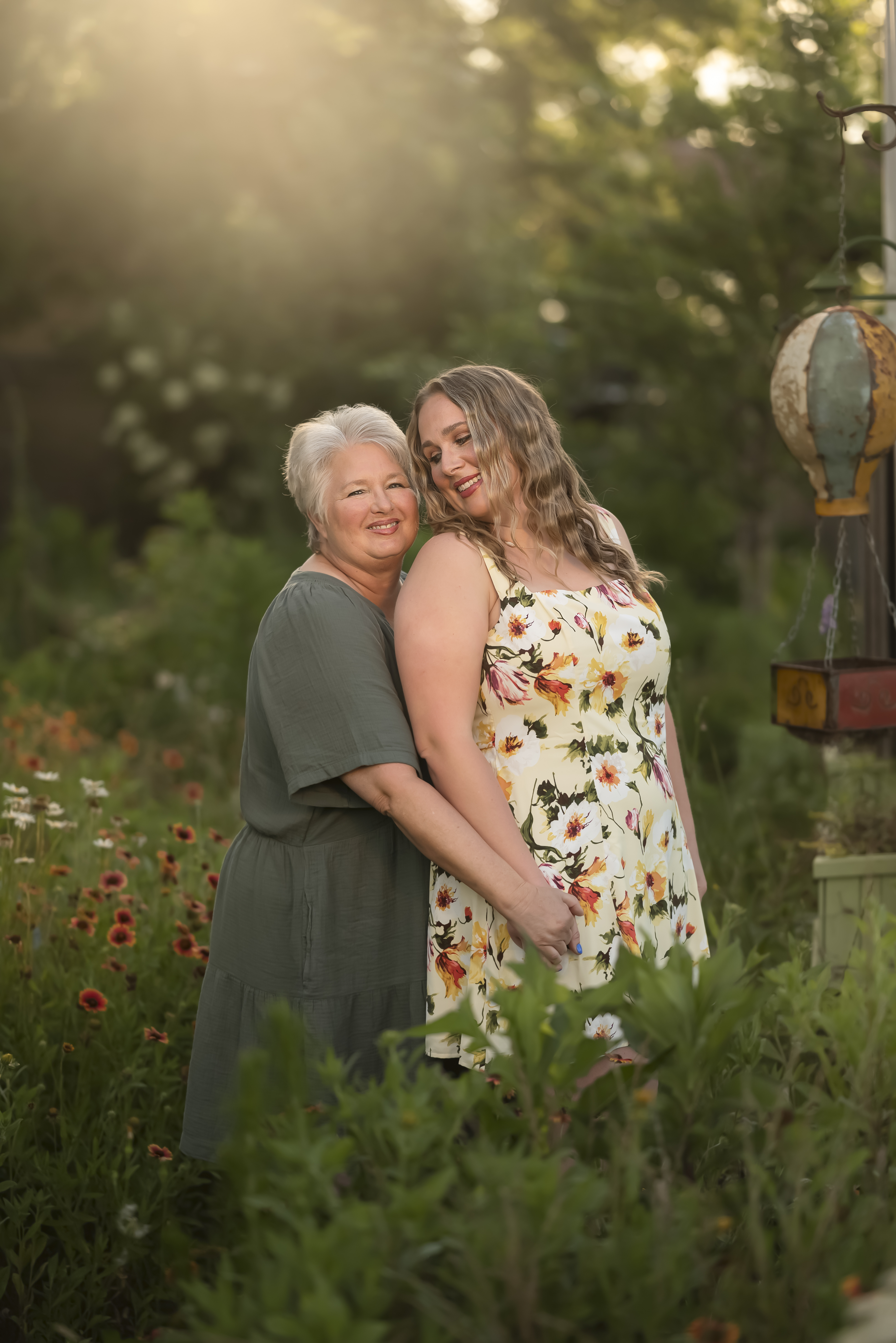 mother and adult daughter portrait, hugging in the south carolina butterfly garden with golden light