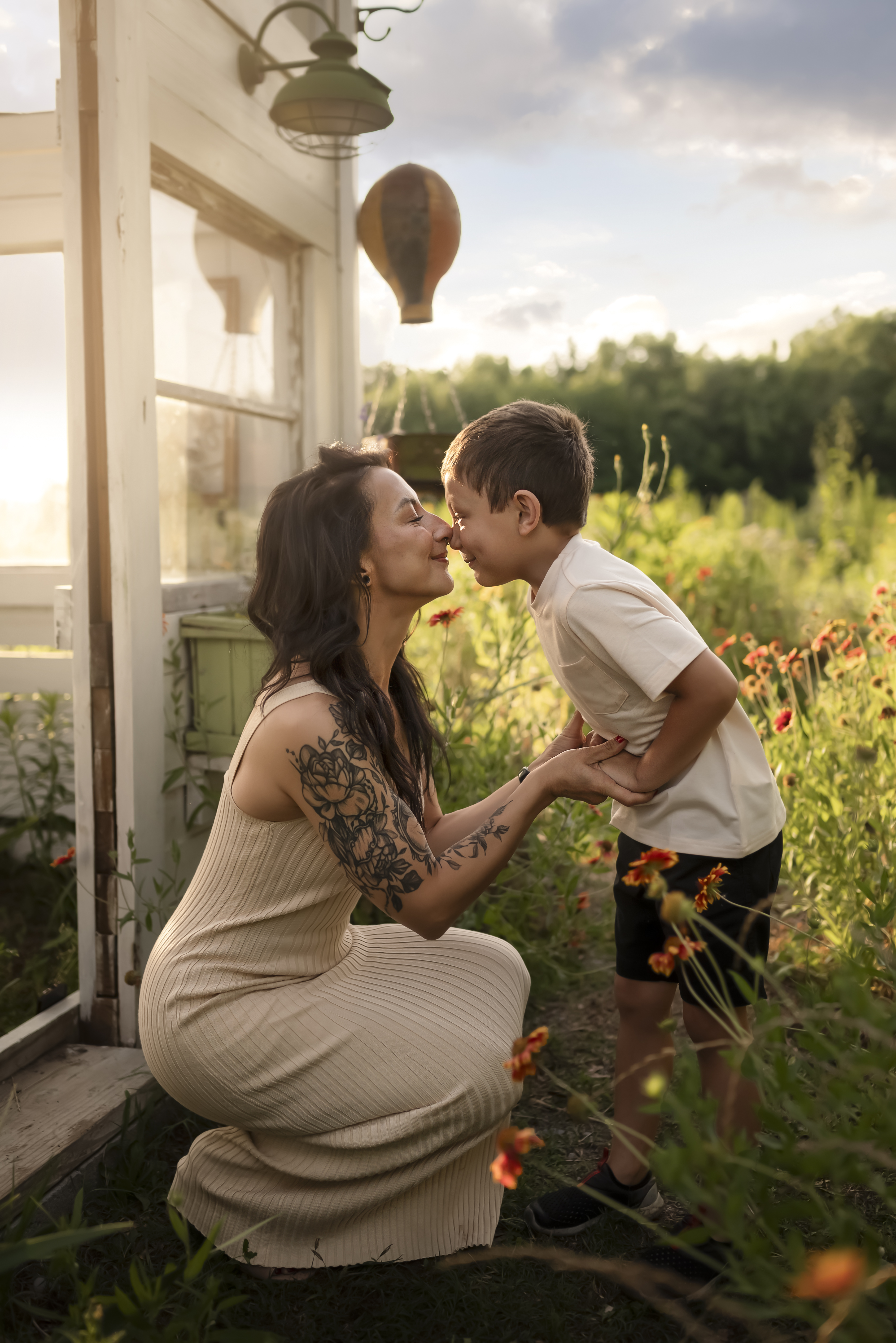 mother and son holding hands in the garden at golden hour